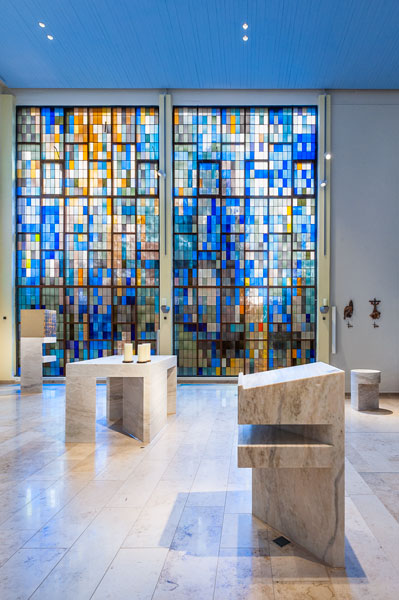 Ambo, Altar, Taufbecken und Tabernakel vor den farbigen Glasfenstern