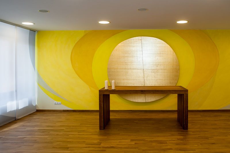Altartisch vor vergoldetem Kreis auf gelb bemalter Wand